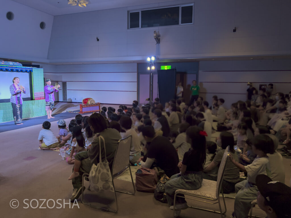 130人余りの観客、竹楽器アンクルンの演奏から始まります。 | おとくにパオ | 影絵音楽団くぷくぷ こわくてなくぞ「ねないこだれだ」 | 子ども劇場おやこ劇場 | インドネシアの影絵とガムラン