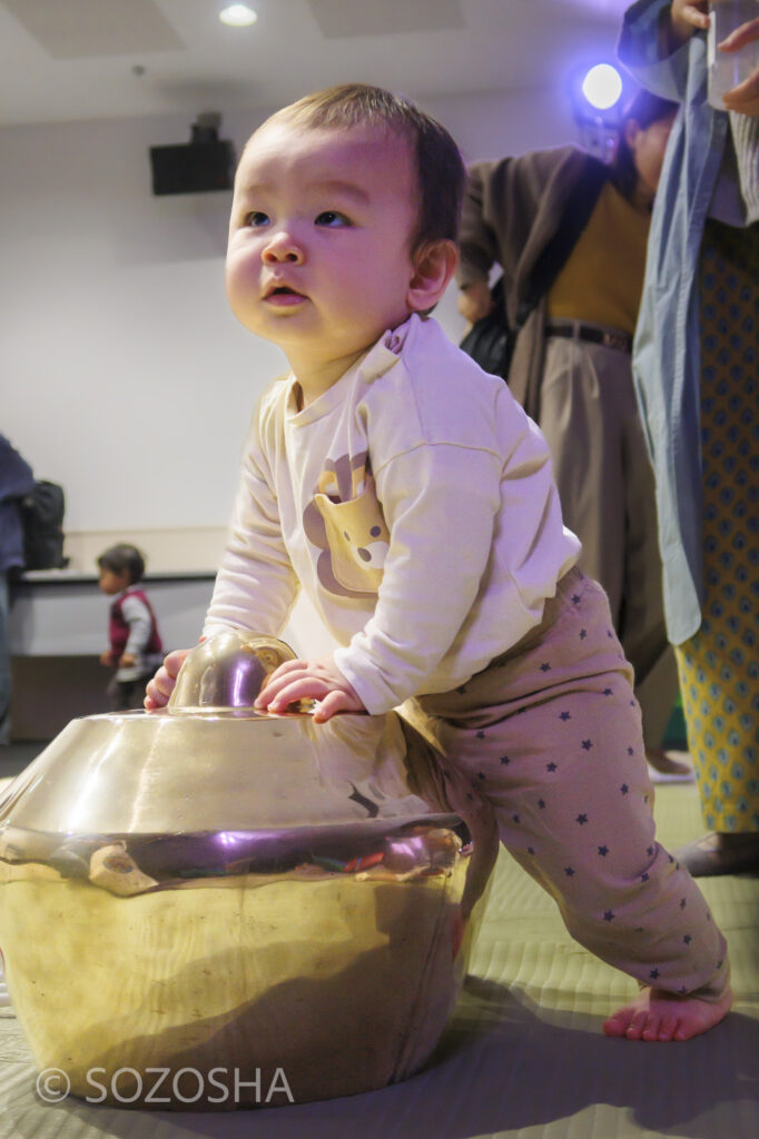 ガムラン楽器に、つかまり立ち | ベイビーシアターフェスティバル4 -町田市民ホール | 影絵音楽団くぷくぷ　おひざにだっこ｢がたんごとん がたんごとん｣ | インドネシアの影絵とガムラン | Baby Theater Festival