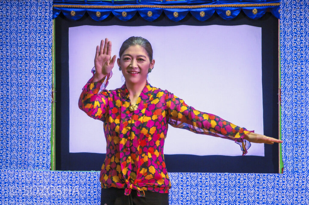 影絵音楽団くぷくぷの出演者が、アンクルンのハンドサインを出している様子